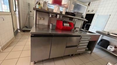 a kitchen with a stainless steel counter and a refrigerator