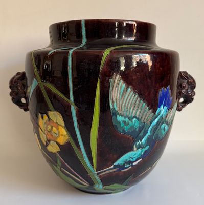 un vase orné d'un papillon peint, posé sur une table