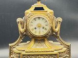 a gold clock sitting on top of a table