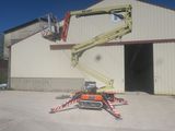 a picture of a man on a cherry picker in front of a building