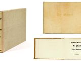 un livre ouvert posé sur une table blanche à côté d'un livre