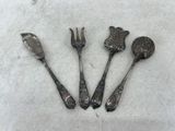 three spoons and a fork are sitting on a white surface