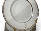 a stack of silver plates on a stand on a white surface