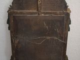 a small wooden cabinet on a table with a white wall in the background