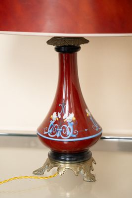 une lampe posée sur une table, avec un abat-jour rouge