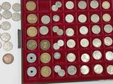 une boîte rouge remplie d'une multitude de pièces d'argent et d'or