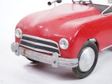 a red toy car that is sitting on a white surface