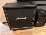 two marshall amps sitting on a hard wood floor next to a wall