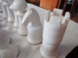 a lot of white ceramic chess pieces on a table