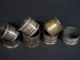 several silver cups are lined up in a row on a black surface