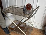 un chariot de bar en verre et en métal posé sur un parquet