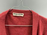 un pull rouge suspendu à un cintre accroché au mur