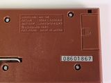 a close up of a brown electronic device on a white surface