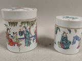 pair of chinese porcelain cups with figures on them on a table