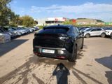 a black car parked in a parking lot with other cars