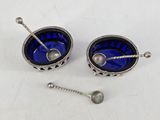pair of silver and blue glass bowls with spoons and spoon rest