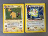 two pokemon cards sitting on top of a table next to each other