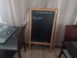 a chalk board in the corner of a restaurant