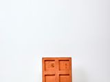 a small orange object sitting on a white surface