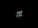 une paire de boucles d'oreilles en émeraudes et diamants sur fond noir