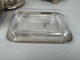 a glass tray with a silver lid on a table