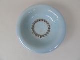 a small blue bowl with a beaded ring in it