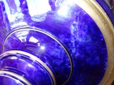 a blue vase with a gold rim sitting on a table
