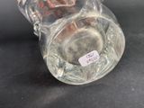 a glass vase with a label on it on a table