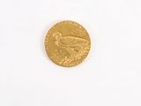 a gold coin with a bird on it on a white surface