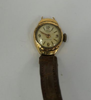 an image of a gold wrist watch with a brown leather strap