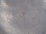 a close up of a silver plate with a crest on it