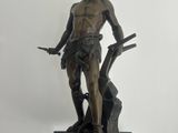 bronze statue of a man with a gun on a wooden base