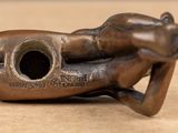 a bronze statue of a hand holding a pipe