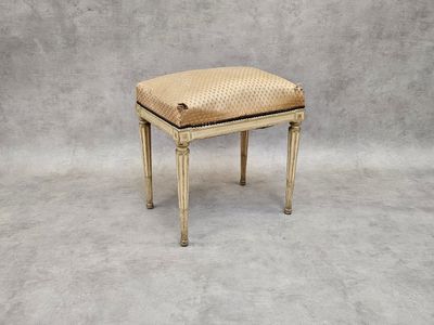 un tabouret ancien avec une assise tressée sur fond gris