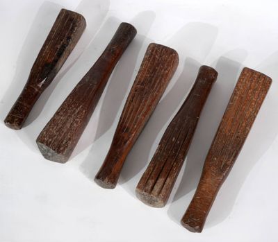 quatre battes de baseball en bois posées sur une surface blanche