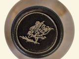 a close up of a black and gold plate with a dragon on it
