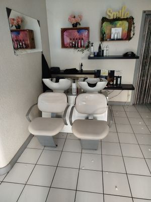 a picture of a salon room with chairs and a mirror