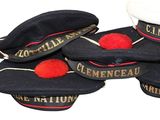 many hats with red pom poms sitting on top of each other