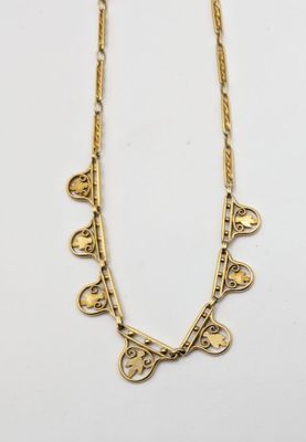 a gold necklace with hearts and leaves on a chain