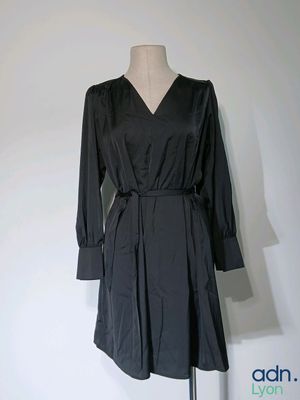 une robe noire sur un pied de mannequin, posée sur un mannequin
