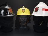 three firemen helmets are lined up against a black background