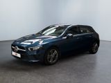 une Mercedes CLA bleue garée dans une pièce blanche
