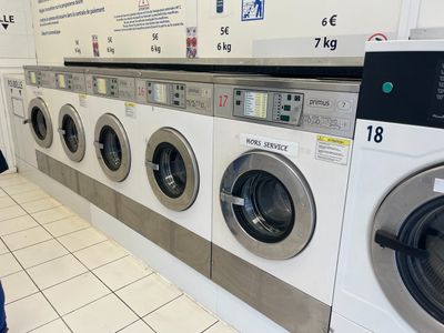 a woman standing in front of a row of washing machines