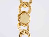 a close up of a gold bracelet on a white background