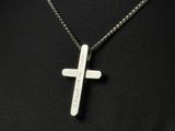 a cross pendant with a message on it is shown on a mannequin