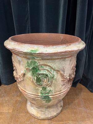 a planter sitting on a table with a curtain in the background