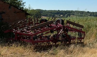 un banc posé au milieu d'un champ, près d'un bâtiment