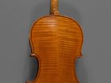 an antique violin with a wooden back and bow on a gray background