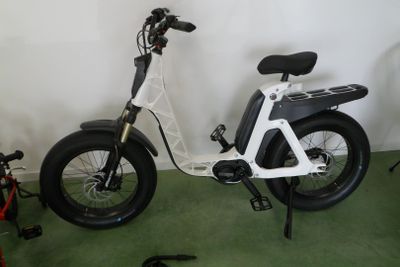 une trottinette électrique blanche avec un siège noir dans une pièce