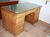 a wooden desk with a glass top in a room